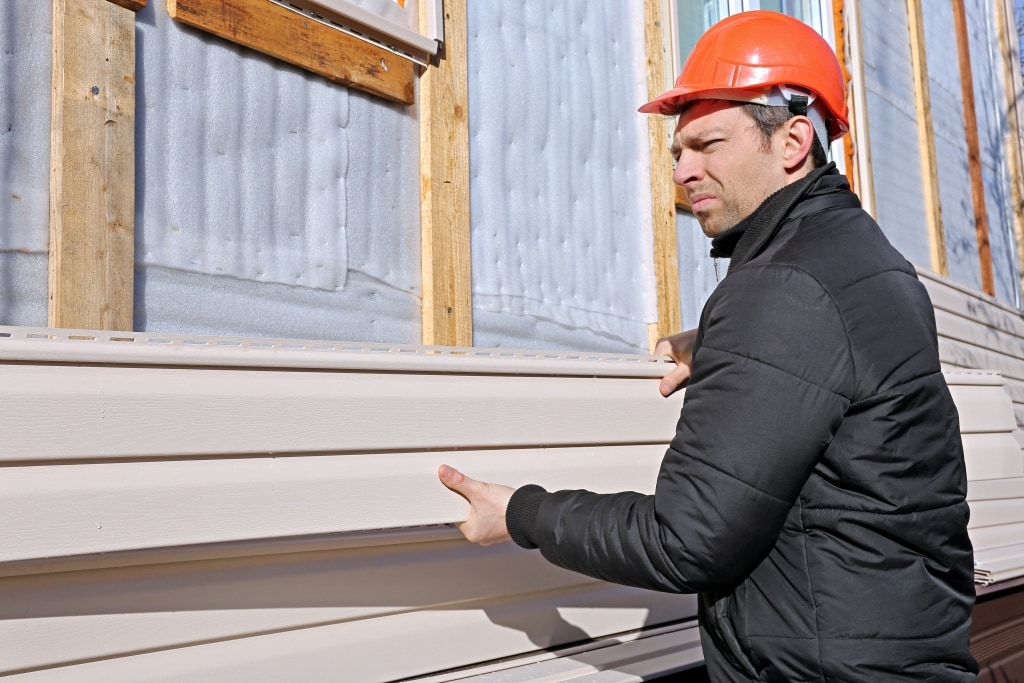 installs hardie panels beige siding on the facade